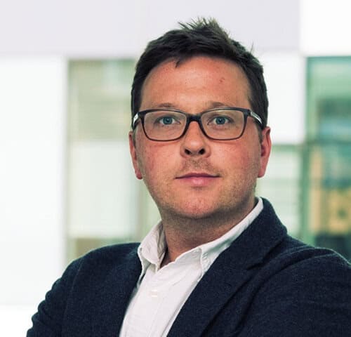 Professional businessman wearing glasses in an office setting.