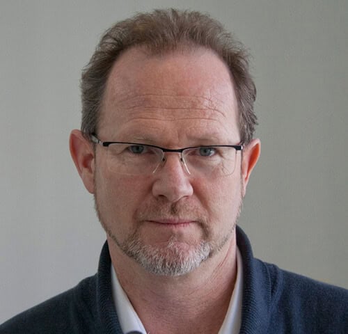 Man with glasses and a beard, wearing a dark sweater.