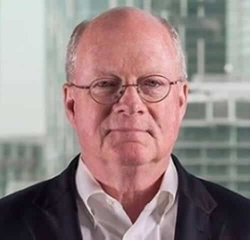 Businessman in formal attire standing in modern glass office building.
