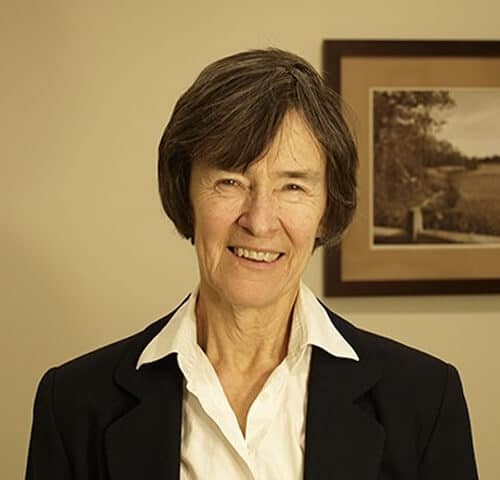 Professional woman smiling in office setting, dressed in business attire, portrait for leadership and expertise.