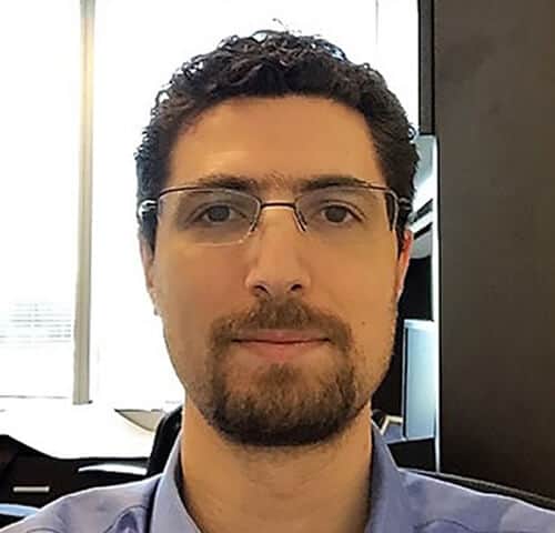 Man wearing glasses in modern office setting.