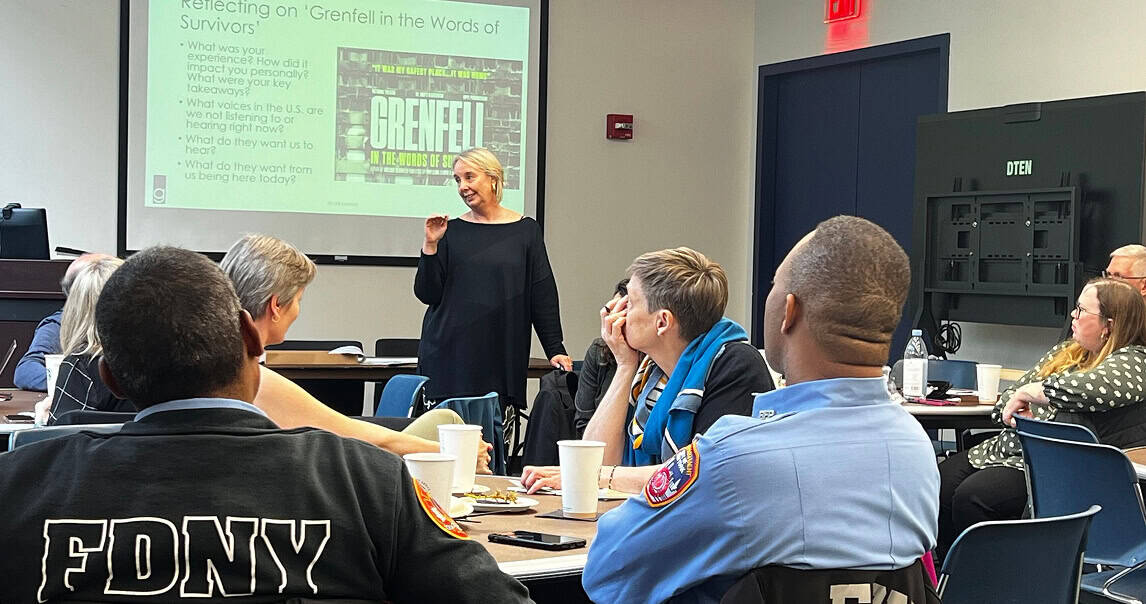 Empowering fire safety training session with diverse emergency responders and a speaker at a conference.