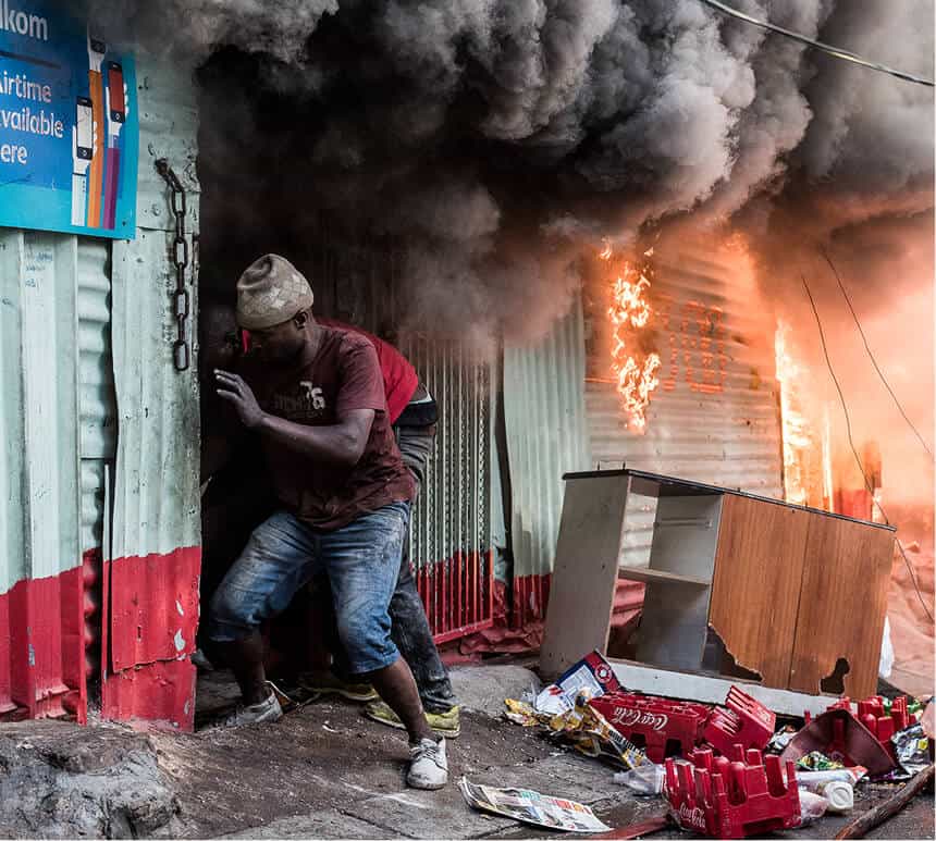 Person attempting to enter a building engulfed with fire and smoke in a burning building during a devastating blaze.