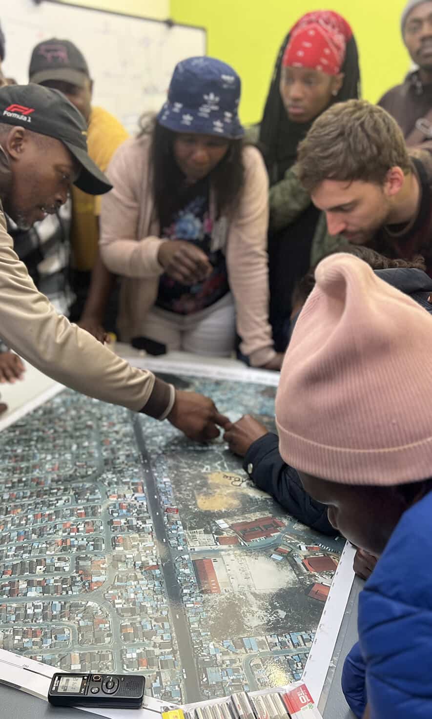 People collaborating around a detailed urban development map during a planning session.
