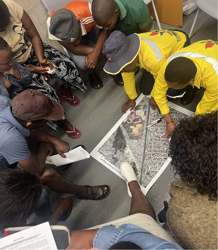 Group of people examining a detailed city map on the floor.
