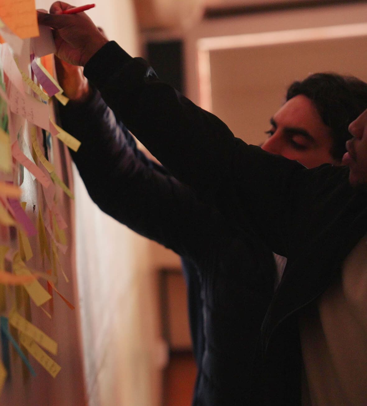 Post-it notes on wall for brainstorming and idea organization.